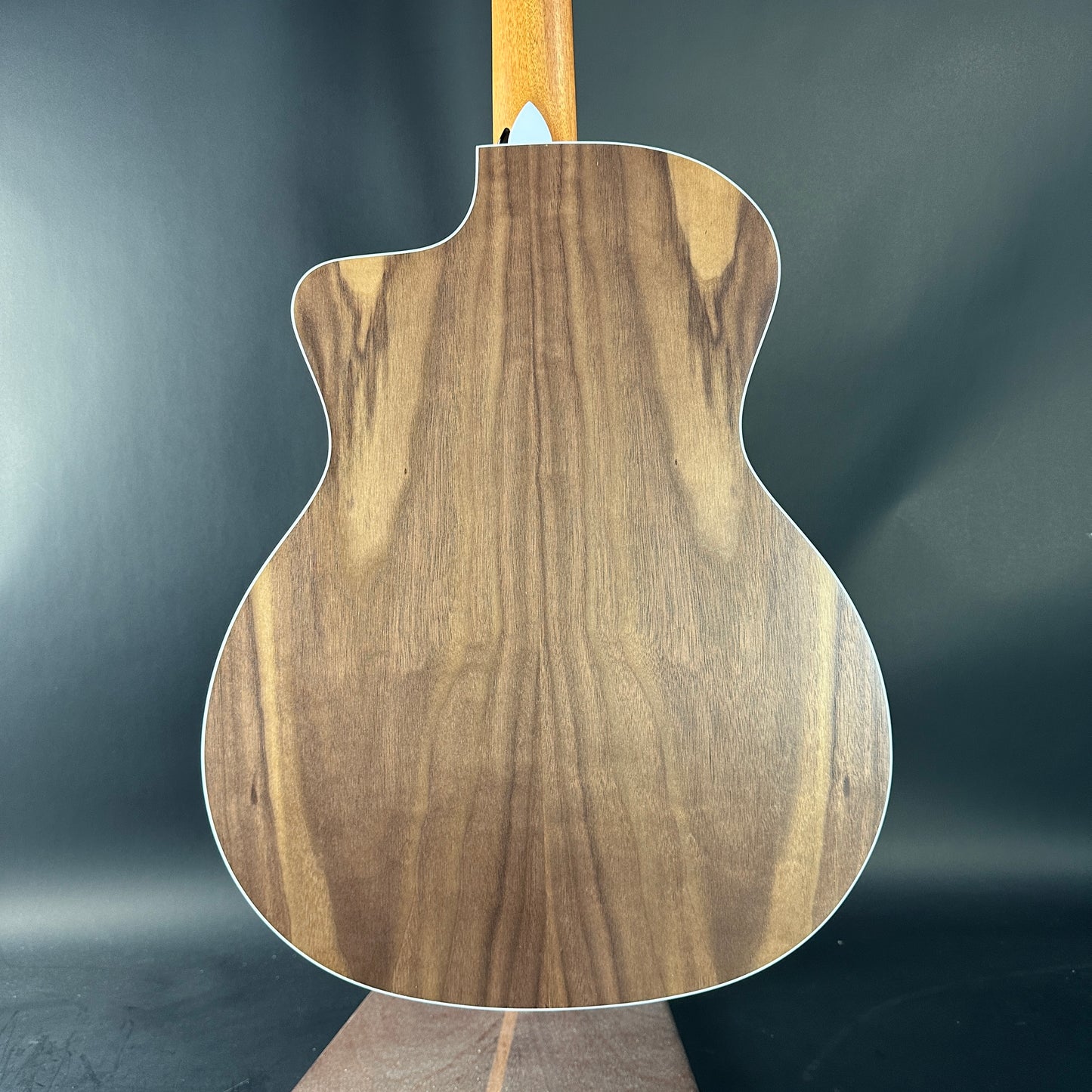 Wooden guitar body on a dark gray background