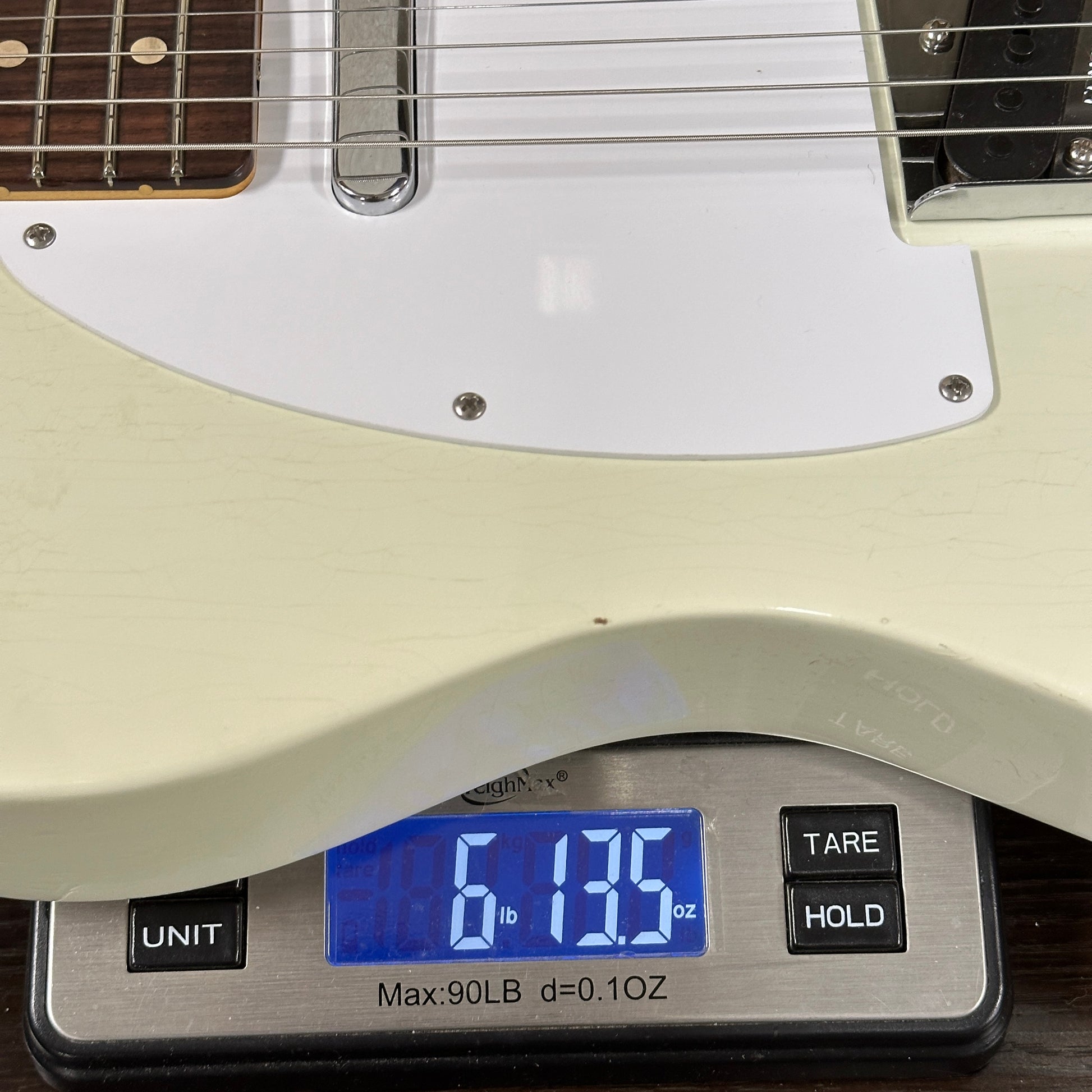 Electric guitar on a digital scale displaying weight