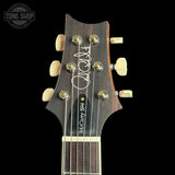 Guitar headstock with brand logo on a black background