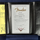 Fender certificate of authenticity in a black leather holder on a blue background