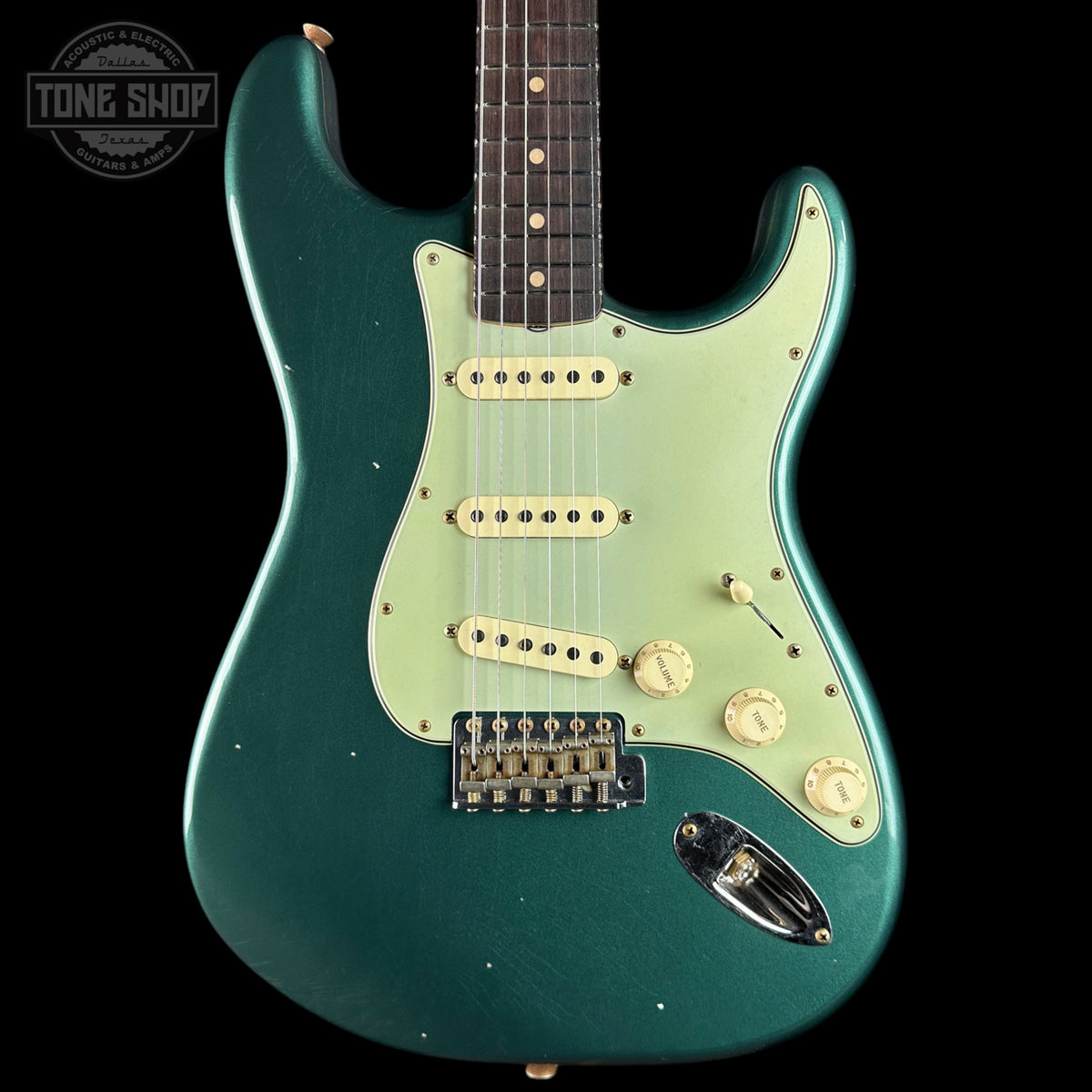 Green electric guitar with a visible brand logo on a black background
