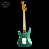 Green electric guitar with a black background