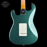 Green electric guitar with a visible brand logo on a black background