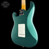 Teal electric guitar with a visible brand logo on a black background