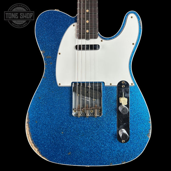 Blue electric guitar with white pickguard on a black background, featuring 'Tone Shop' logo.