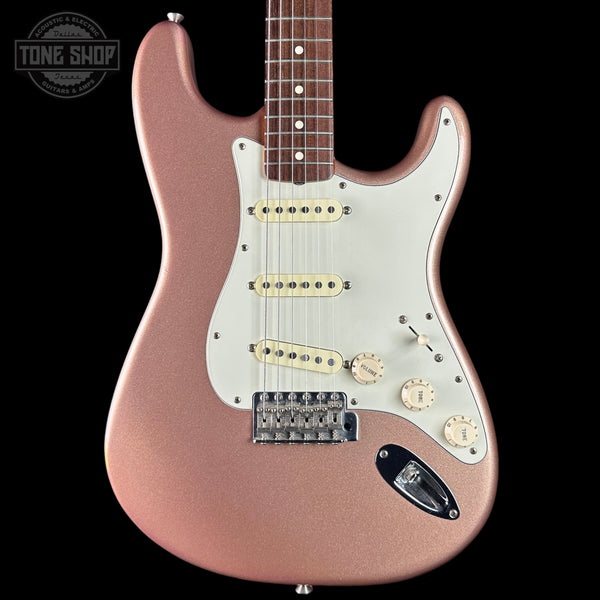 Electric guitar with a rose gold finish on a black background, featuring the Tone Shop logo.