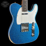 Blue electric guitar with a white pickguard on a black background