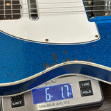 Blue electric guitar on a digital scale displaying weight