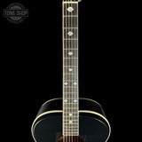 Close-up of a guitar neck with a black background and 'Tone Shop' logo.