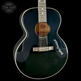 Acoustic guitar with a black finish on a black background, featuring the 'Tone Shop' logo.