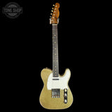 Gold glitter electric guitar with a white pickguard on a black background, featuring 'Tone Shop' branding.