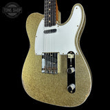 Gold glitter electric guitar with a white pickguard on a black background, featuring 'Tone Shop' logo.