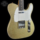 Gold glitter electric guitar with a white pickguard on a black background, featuring 'Tone Shop' logo.