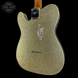 Back view of a glittery gold electric guitar body with a visible brand logo on a black background.