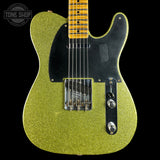 Green glitter electric guitar with a black pickguard on a black background, featuring 'Tone Shop' logo.