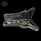 Guitar in a clear case with 'Tone Shop' logo in the corner