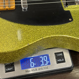 Green glittery guitar on a digital scale displaying weight