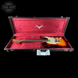 Guitar in a red-lined case with a visible brand logo on a black background