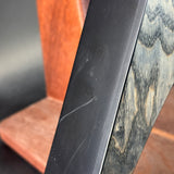 Close-up of a wooden chair armrest and black metal frame.