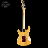 A natural wood electric guitar shown from the back against a solid black background, with a Tone Shop watermark in the top-left corner.