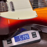 Electric guitar on a digital scale displaying weight