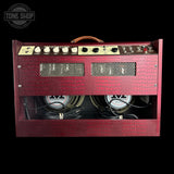 A vintage-style guitar amplifier head with a textured red front, cream control panel, and two visible speakers inside, photographed against a black background. A Tone Shop watermark appears in the upper left corner.