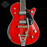 Red electric guitar with a black pickguard on a black background, featuring the Greco brand.