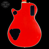 Red electric guitar body with 'Tone Shop' logo in the corner
