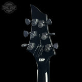Close-up of a guitar headstock with 'ESP' branding on a black background.