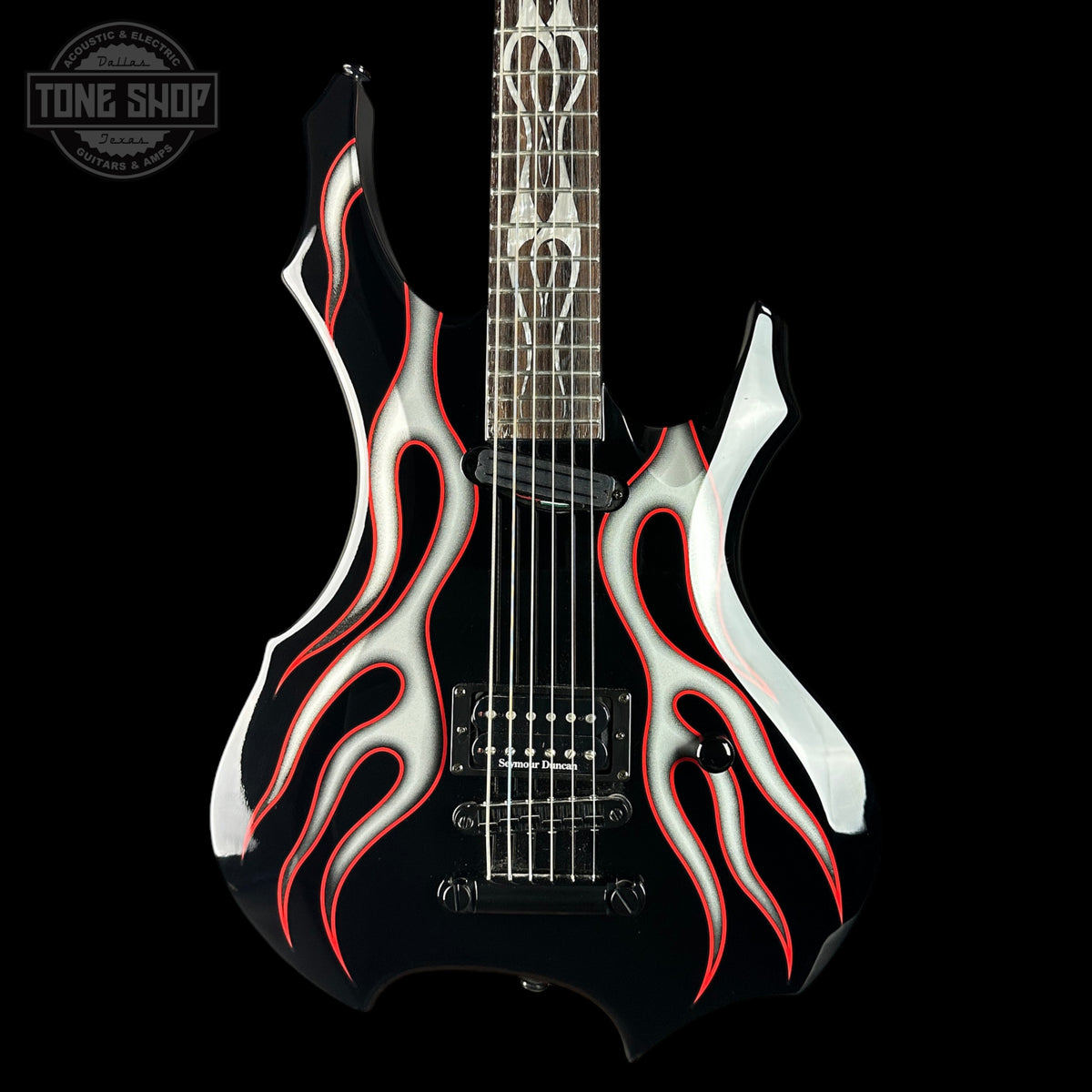 Guitar with flame design on a black background, featuring the Tone Shop logo.