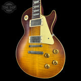 Gibson Les Paul electric guitar with a sunburst finish on a black background, featuring the Tone Shop logo.