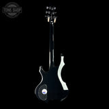 Black electric guitar on a black background with 'Tone Shop' logo.