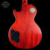 Red electric guitar body with a visible brand label on a black background