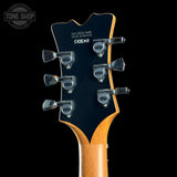 Guitar headstock with tuning pegs on a black background, featuring 'Tone Shop' branding.