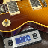 Electric guitar on a digital scale displaying weight