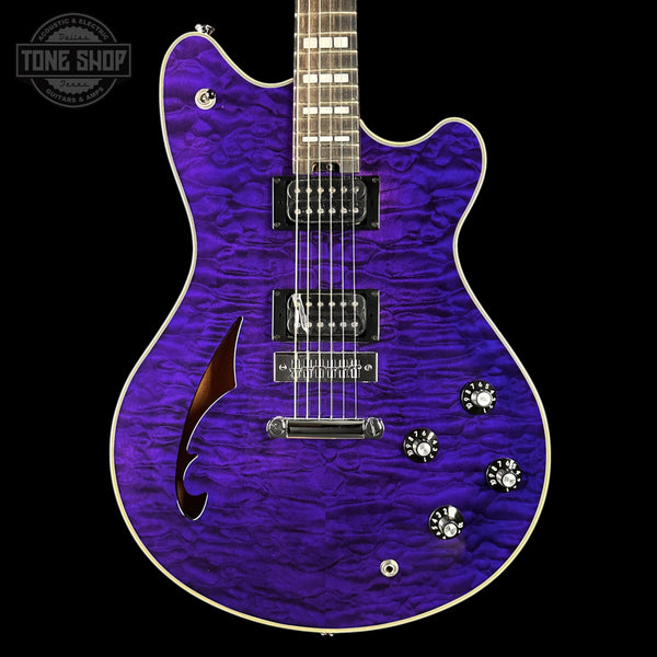 Purple electric guitar with a quilted finish on a black background, featuring the Tone Shop logo.