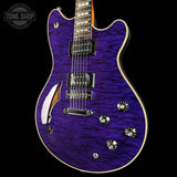 Purple electric guitar with a wavy finish on a black background, featuring the Tone Shop logo.