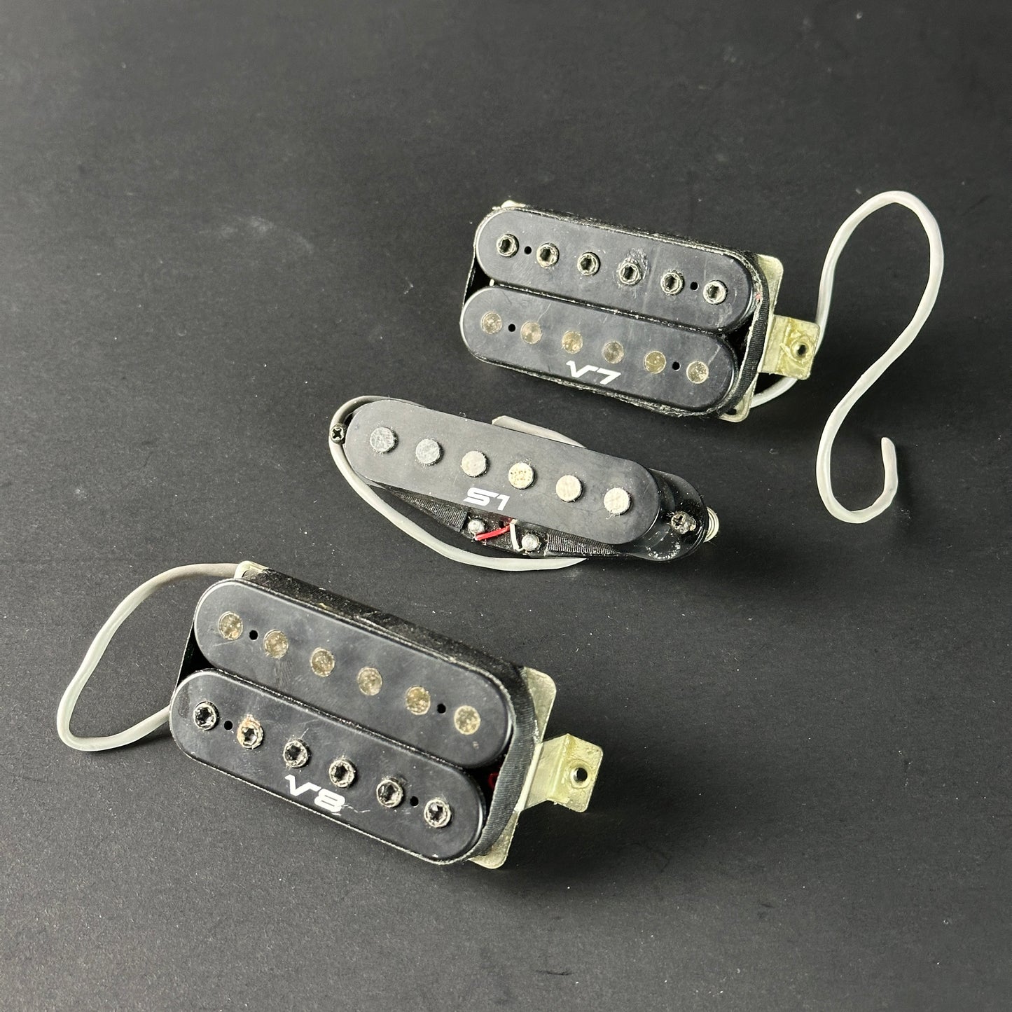 Three guitar pickups on a dark background