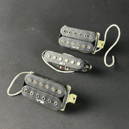 Three guitar pickups on a dark background