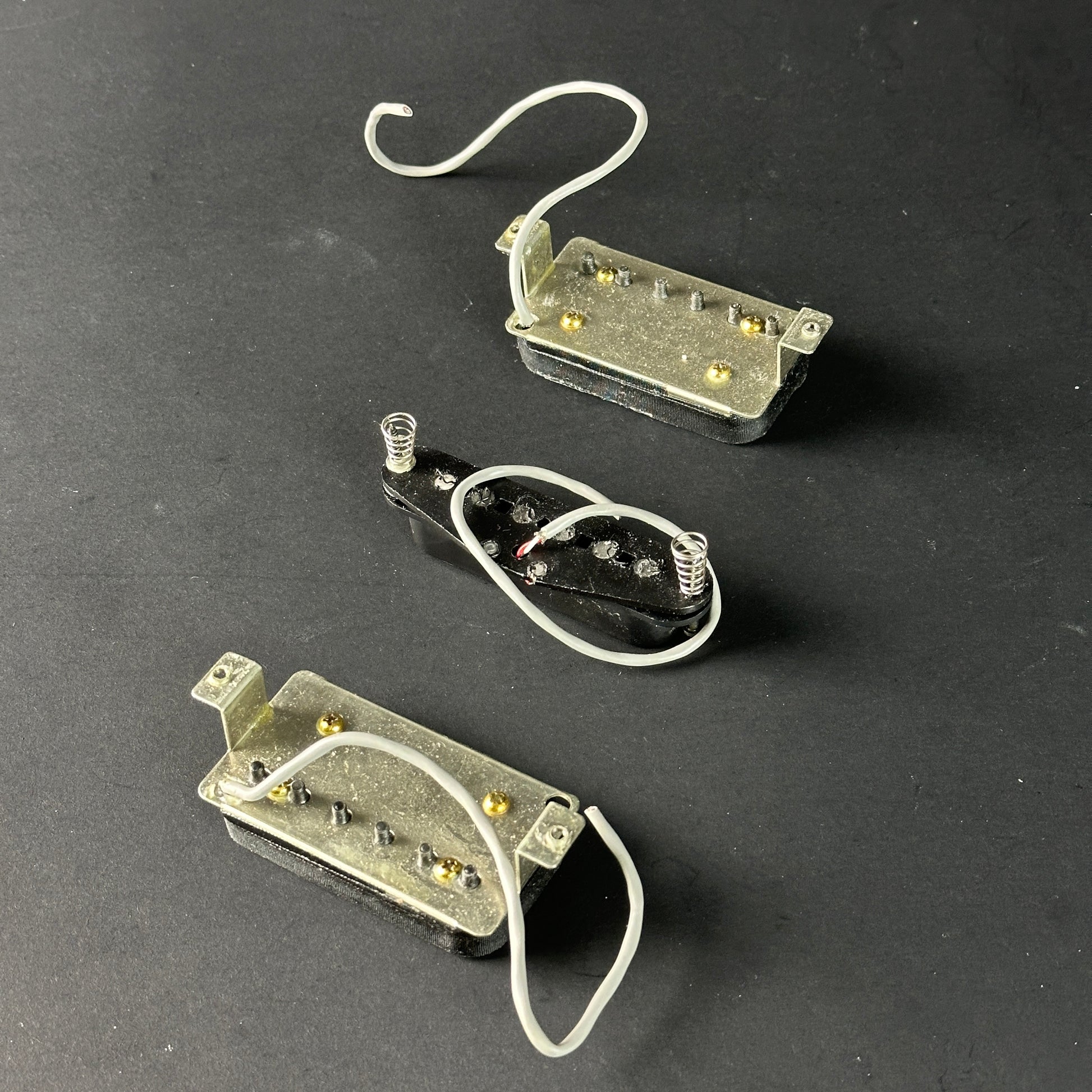 Three guitar pickups on a dark gray background