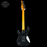 Black electric guitar with a yellow neck on a white background, featuring 'Tone Shop' branding.