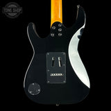 Black electric guitar with a white pickguard on a black background, featuring the Tone Shop logo.