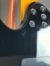 Close-up of a guitar's soundhole with screws and wood finish.