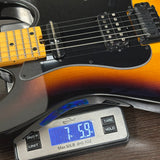 Electric guitar on a digital scale displaying weight