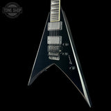 Black electric guitar with a unique body shape on a black background, featuring the Tone Shop logo.