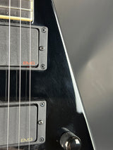 Close-up of a black electric guitar with visible brand logos.