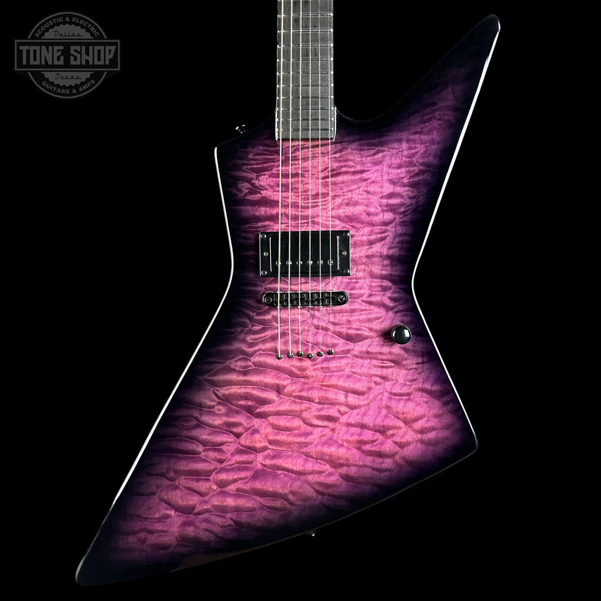 A modern electric guitar with a distinctive angular body, featuring a vibrant magenta and purple flamed maple top with a black finish. The neck is dark wood, and the guitar is photographed against a solid black background with a Tone Shop watermark in the upper left corner.