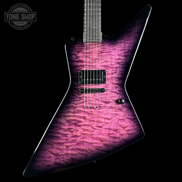 A modern electric guitar with a distinctive angular body, featuring a vibrant magenta and purple flamed maple top with a black finish. The neck is dark wood, and the guitar is photographed against a solid black background with a Tone Shop watermark in the upper left corner.
