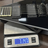 Black electric guitar on a digital scale displaying weight