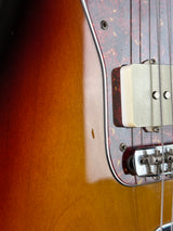 Close-up of a guitar's body and neck with a focus on the hardware.